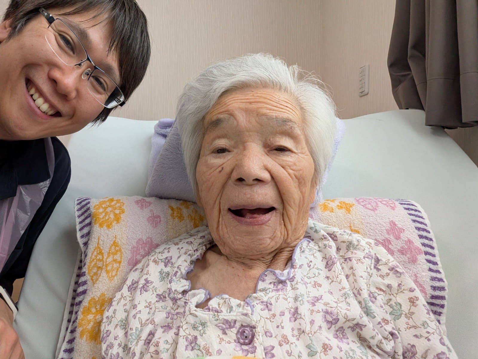 介護の現場で利用者さんと笑顔で語り合う講師の佐野克浩